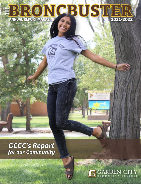 Cover of the “Broncbuster Annual Report Magazine 2021–2022” showing a student outdoors on campus posing near a tree at Garden City Community College.