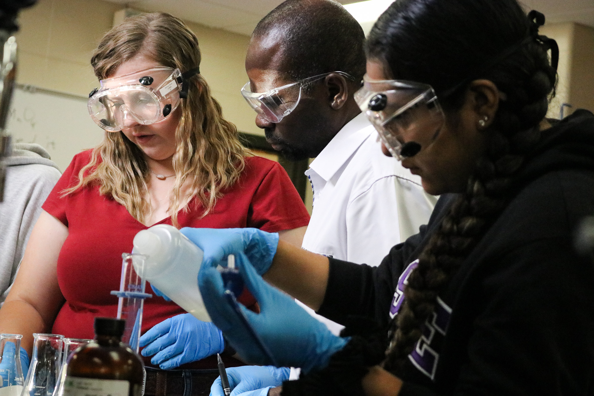 students and lab teacher wearing goggles.